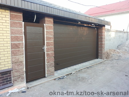 Секционные ворота с калиткой в фасаде